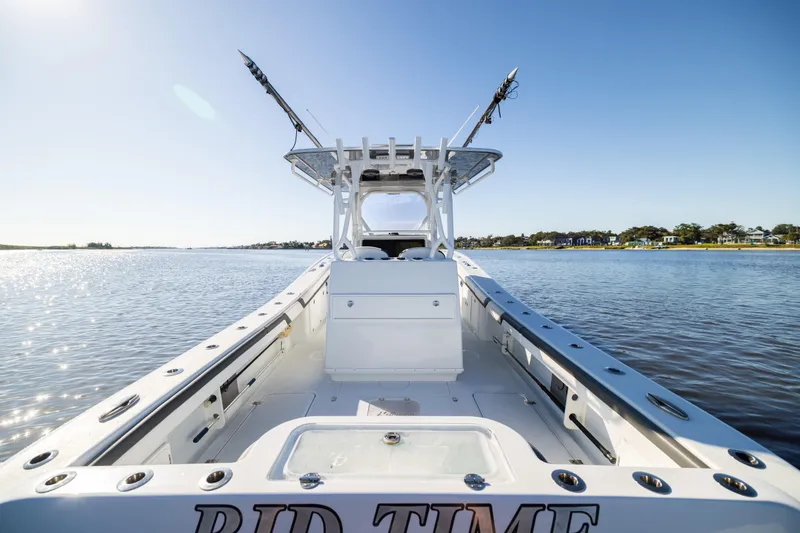 Bid Time 2 Yacht Photos Pics 2023 Yellowfin 36 Offshore boat on calm water, clear sky, fishing rods visible.