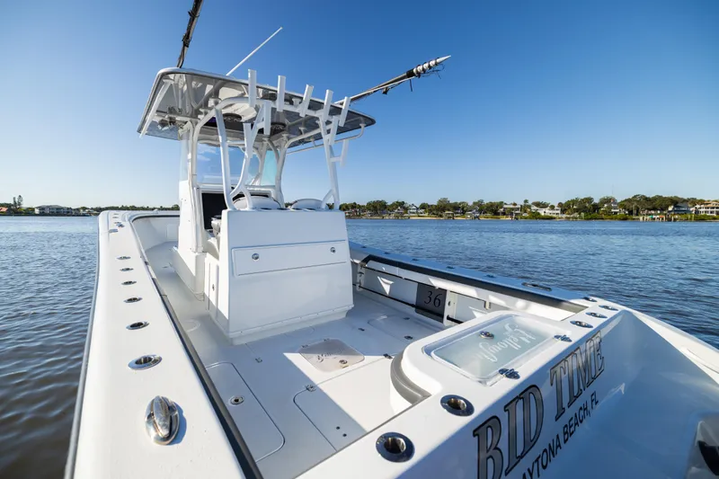 Bid Time 2 Yacht Photos Pics 2023 Yellowfin 36 Offshore boat on calm water, featuring sleek design and spacious deck.