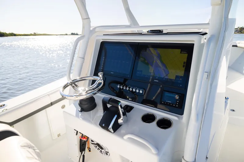 Bid Time 2 Yacht Photos Pics 2023 Yellowfin 36 Offshore boat dashboard with navigation screens and steering wheel.