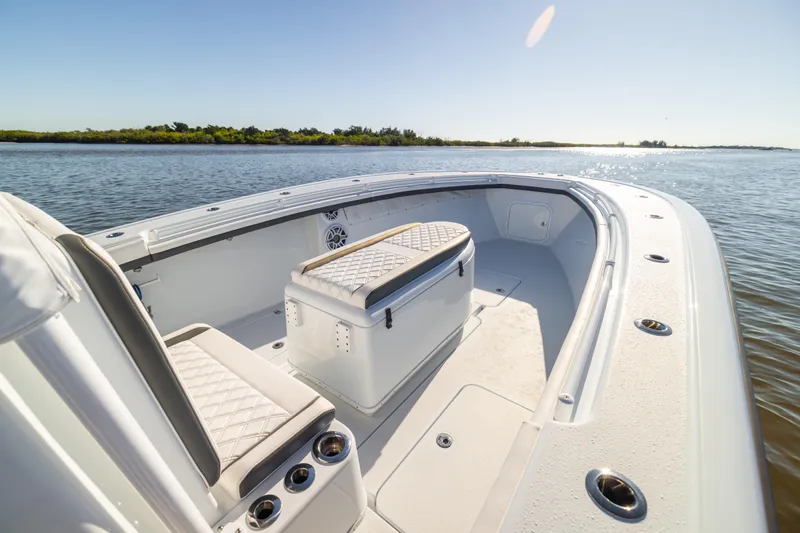 Bid Time 2 Yacht Photos Pics 2023 Yellowfin 36 Offshore boat interior with seating and storage, on calm water.