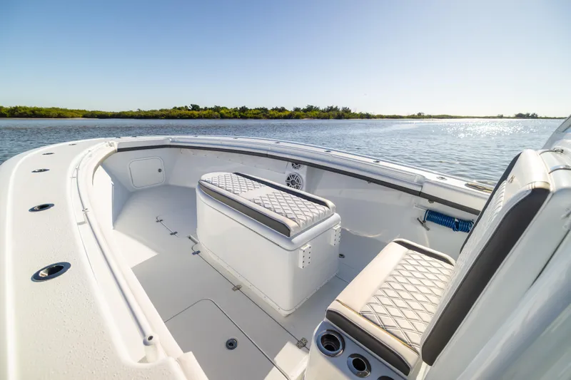 Bid Time 2 Yacht Photos Pics 2023 Yellowfin 36 Offshore boat interior with seating, on a sunny day by the water.