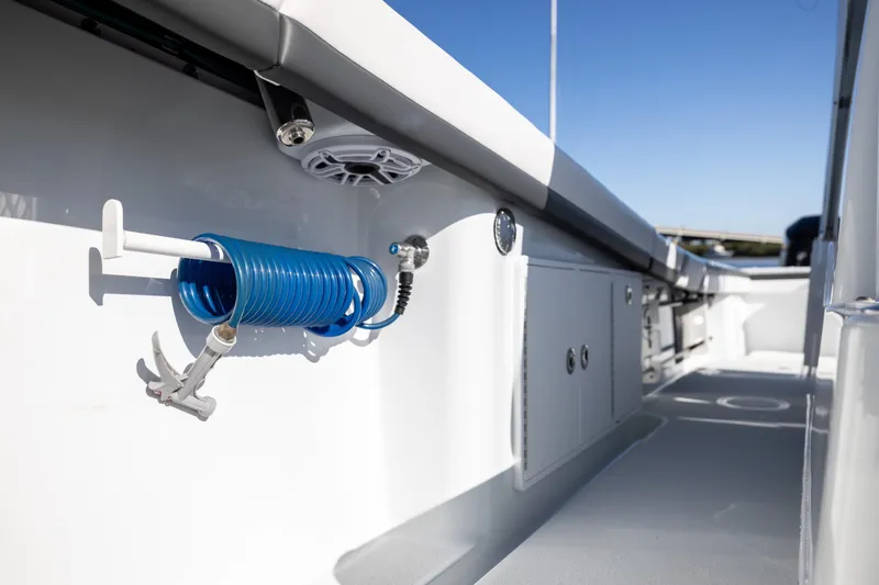 Bid Time 2 Yacht Photos Pics 2023 Yellowfin 36 Offshore boat deck with coiled blue hose and storage compartments.