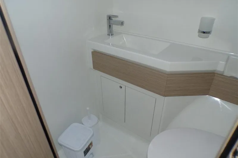 Skyfall Yacht Photos Pics Bathroom interior of 2025 Beneteau Oceanis 46.1 yacht, featuring modern sink and storage.