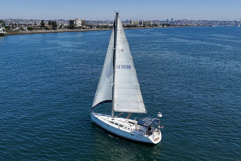  Yacht Photos Pics Sailboat Jeanneau Sun Odyssey 43, 2002 model, cruising on calm blue waters.