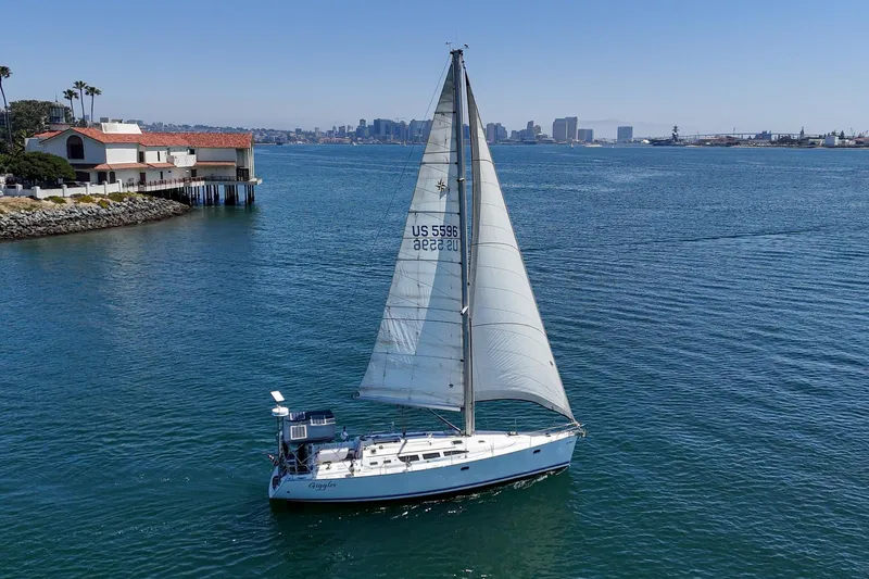  Yacht Photos Pics Sailboat Jeanneau Sun Odyssey 43, 2002 model, cruising near coastal buildings and city skyline.