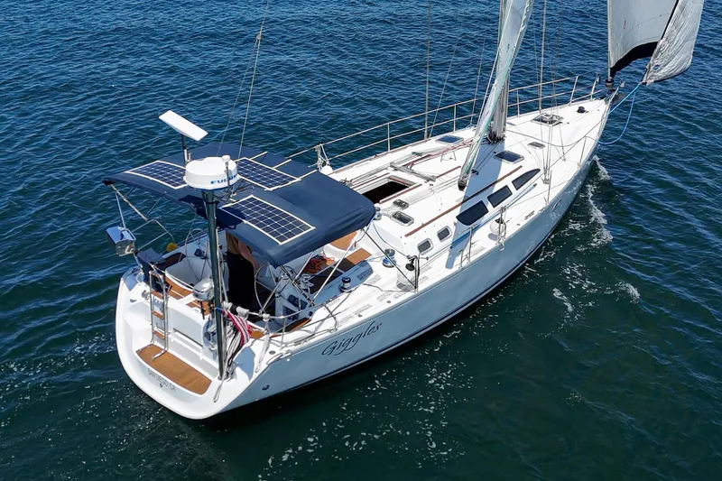  Yacht Photos Pics 2002 Jeanneau Sun Odyssey 43 sailboat on open water, featuring solar panels and sleek design.