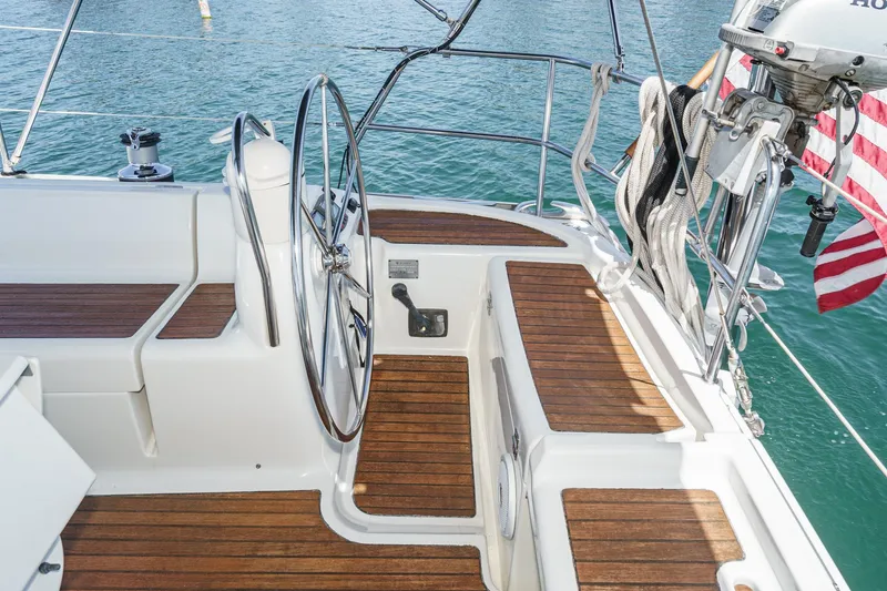 Yacht Photos Pics Cockpit of 2002 Jeanneau Sun Odyssey 43 sailboat with wooden deck and steering wheel.