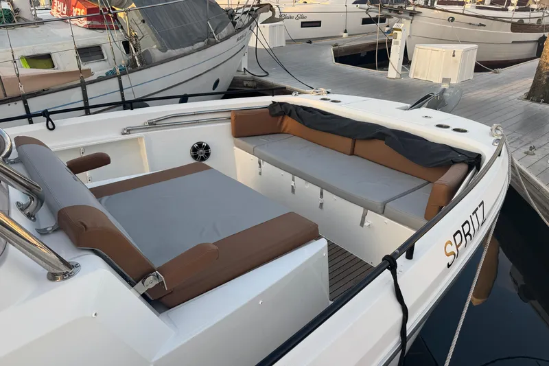 Spritz Yacht Photos Pics 2022 Beneteau Flyer 9 SPACEdeck boat with cushioned seating at a marina.