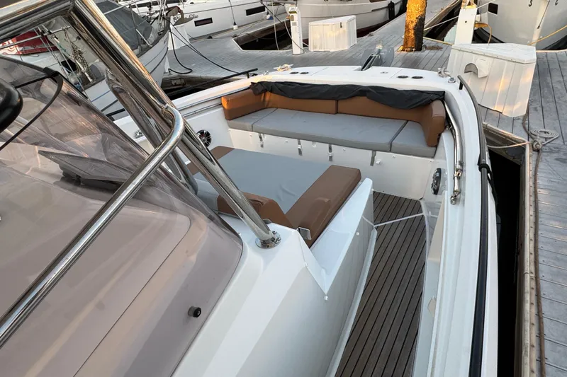 Spritz Yacht Photos Pics 2022 Beneteau Flyer 9 SPACEdeck boat interior with cushioned seating and sleek design.