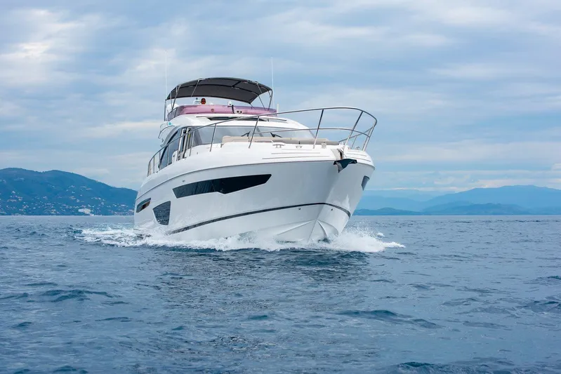 M/y Far Away Yacht Photos Pics Luxurious 2019 Princess S65 yacht cruising on open sea with scenic mountain backdrop.