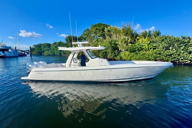  Yacht Photos Pics 2020 Intrepid 375 Nomad SE boat on calm water, surrounded by lush greenery.