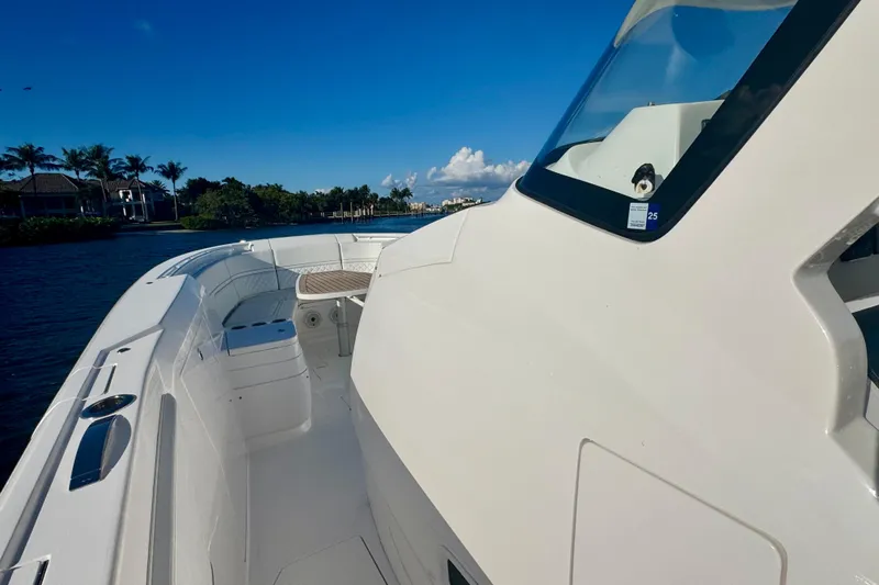  Yacht Photos Pics 2020 Intrepid 375 Nomad SE boat on calm water, clear sky, and lush shoreline.