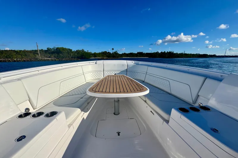  Yacht Photos Pics 2020 Intrepid 375 Nomad SE boat interior with wooden table, cup holders, and scenic water view.