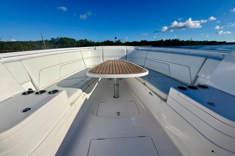  Yacht Photos Pics 2020 Intrepid 375 Nomad SE boat interior with seating and table, under clear blue sky.