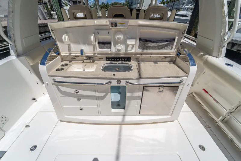  Yacht Photos Pics 2017 Boston Whaler 420 Outrage boat kitchen area with sink, storage, and countertop.