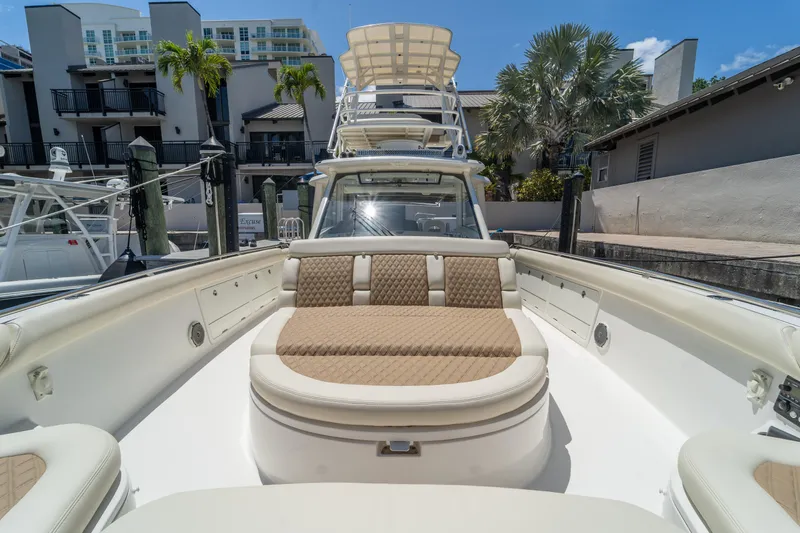  Yacht Photos Pics 2017 Boston Whaler 420 Outrage boat with luxurious seating, docked near modern buildings.
