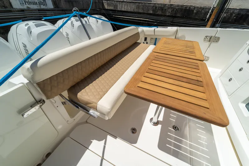  Yacht Photos Pics 2017 Boston Whaler 420 Outrage boat with cushioned seating and wooden table on deck.