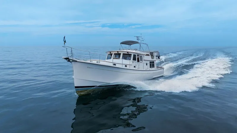 Dogfish Yacht Photos Pics 2023 Krogen Express 52 yacht cruising on open water under clear blue skies.