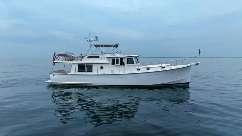 Dogfish Yacht Photos Pics 2023 Krogen Express 52 yacht on calm ocean waters under a cloudy sky.