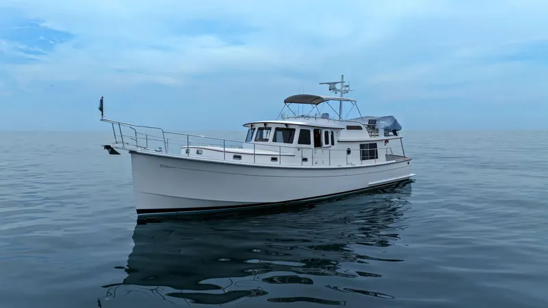 Dogfish Yacht Photos Pics 2023 Krogen Express 52 yacht on calm ocean waters under a clear sky.