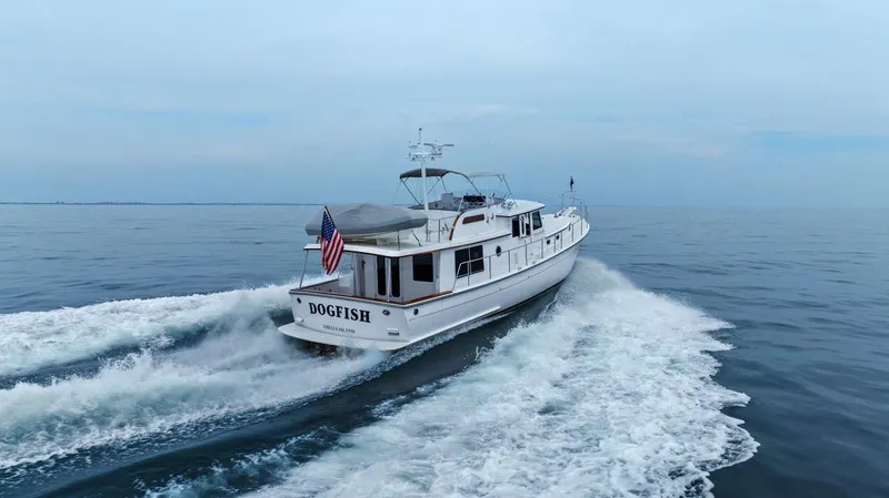 Dogfish Yacht Photos Pics 2023 Krogen Express 52 yacht cruising on open water, rear view.