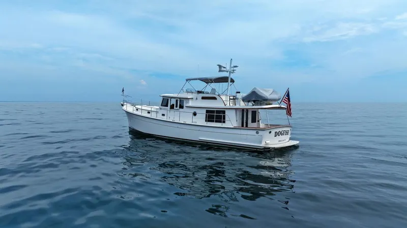 Dogfish Yacht Photos Pics 2023 Krogen Express 52 yacht on calm ocean waters under a clear sky.