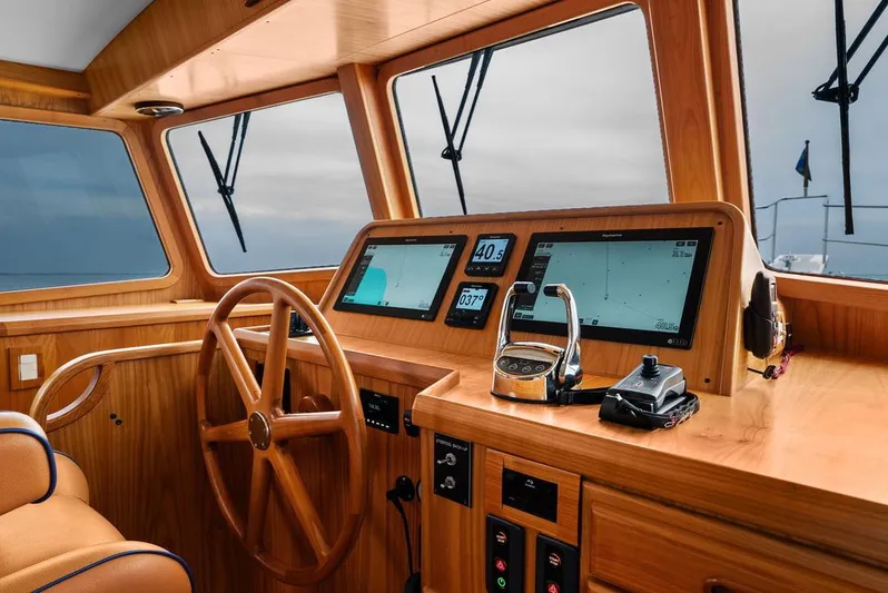 Dogfish Yacht Photos Pics Helm of 2023 Krogen Express 52 yacht with wooden finish and modern navigation displays.
