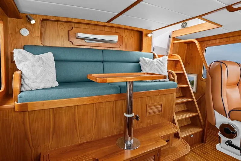 Dogfish Yacht Photos Pics Luxurious interior of 2023 Krogen Express 52 yacht with wooden finish and blue seating.