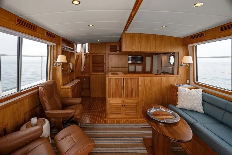Dogfish Yacht Photos Pics Luxurious interior of 2023 Krogen Express 52 yacht with wood paneling and comfortable seating.