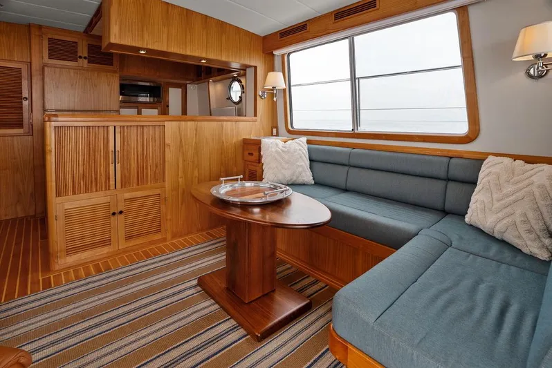 Dogfish Yacht Photos Pics Luxurious interior of 2023 Krogen Express 52 yacht with wood finishes and cozy seating.