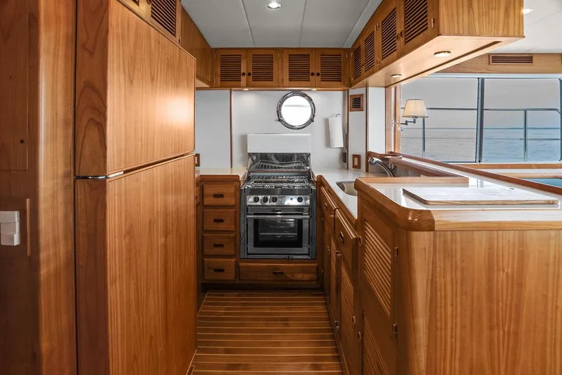 Dogfish Yacht Photos Pics Luxurious 2023 Krogen Express 52 yacht kitchen with wood cabinetry and ocean view.