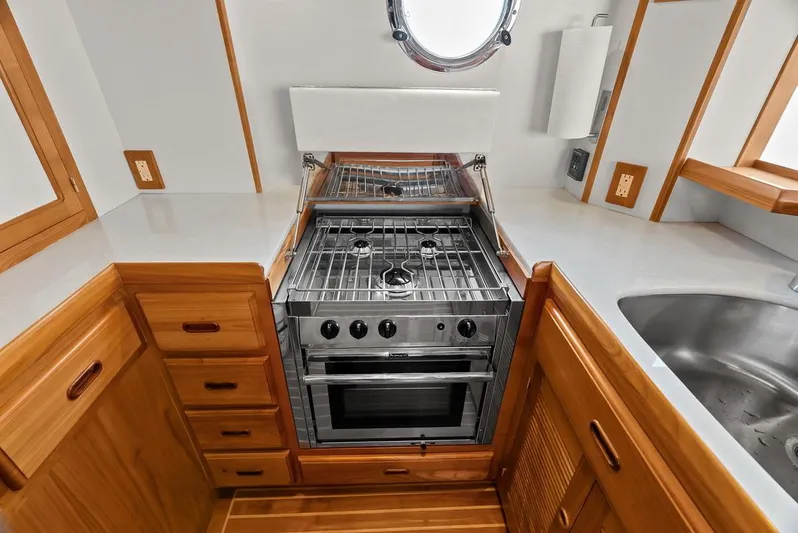 Dogfish Yacht Photos Pics Modern kitchen in 2023 Krogen Express 52 yacht with stove, sink, and wooden cabinetry.