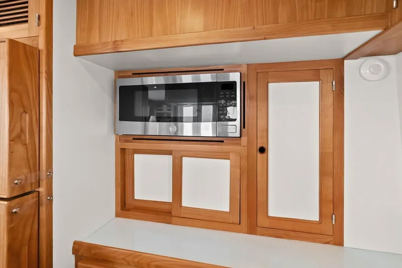 Dogfish Yacht Photos Pics 2023 Krogen Express 52 interior with built-in microwave and wooden cabinetry.