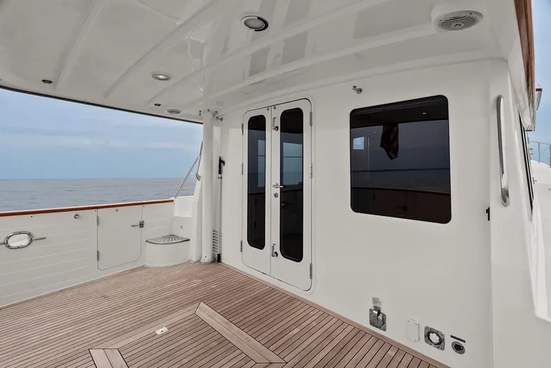 Dogfish Yacht Photos Pics 2023 Krogen Express 52 yacht deck with wooden flooring and ocean view.