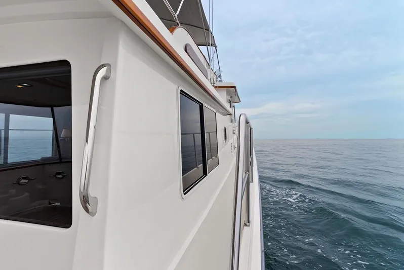 Dogfish Yacht Photos Pics 2023 Krogen Express 52 yacht cruising on open sea under clear sky.