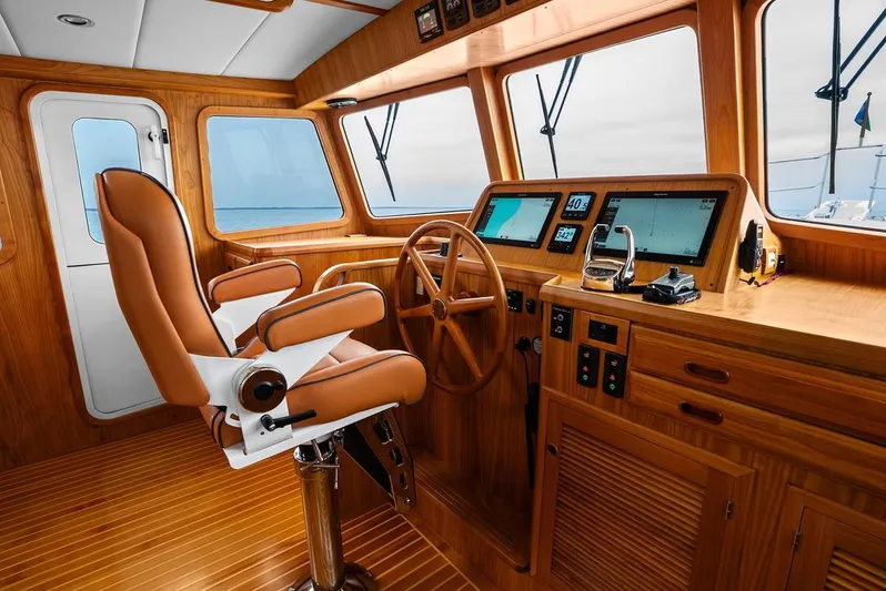 Dogfish Yacht Photos Pics Luxurious helm of 2023 Krogen Express 52 yacht with wooden interior and modern navigation equipment.