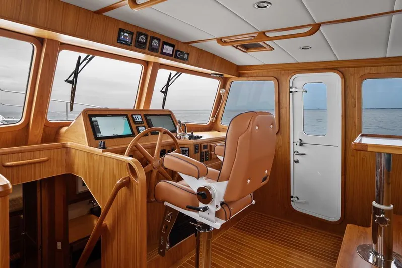 Dogfish Yacht Photos Pics Luxurious helm of 2023 Krogen Express 52 yacht with wooden interior and modern navigation equipment.