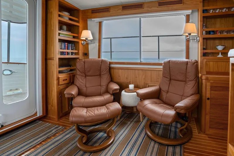 Dogfish Yacht Photos Pics Luxurious 2023 Krogen Express 52 yacht interior with leather chairs and wooden cabinetry.