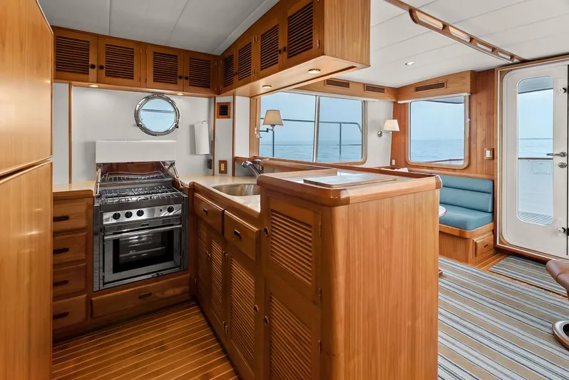 Dogfish Yacht Photos Pics Luxurious 2023 Krogen Express 52 yacht interior with wooden cabinetry and ocean view.