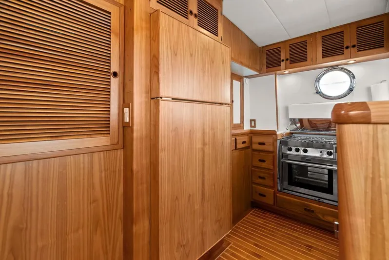 Dogfish Yacht Photos Pics 2023 Krogen Express 52 yacht kitchen with wood cabinetry and stainless steel appliances.