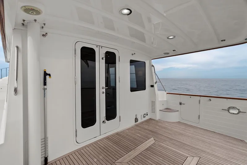 Dogfish Yacht Photos Pics 2023 Krogen Express 52 yacht deck with ocean view, featuring sleek design and wooden flooring.