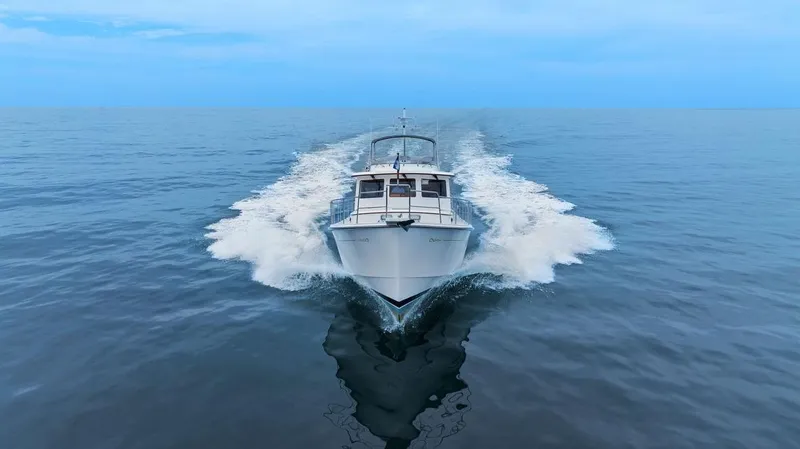 Dogfish Yacht Photos Pics 2023 Krogen Express 52 cruising on open water, creating a dynamic wake.