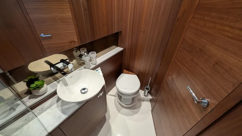  Yacht Photos Pics Luxurious bathroom in 2021 Princess V50 yacht with modern fixtures and wood paneling.