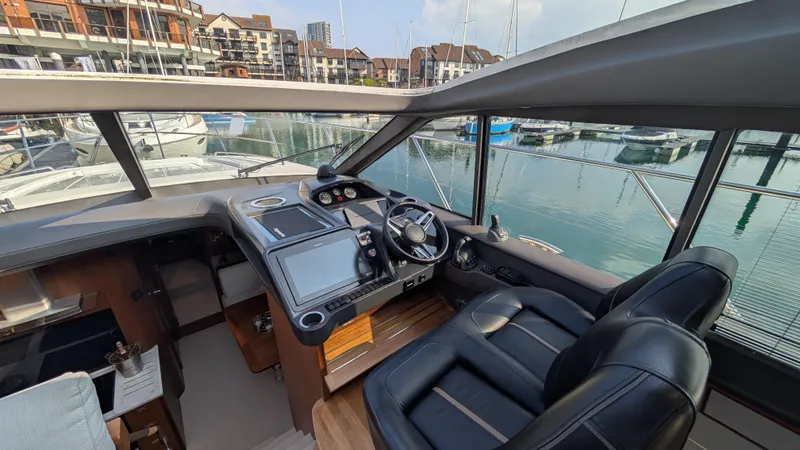  Yacht Photos Pics Interior of a 2021 Princess V50 yacht with modern dashboard and marina view.