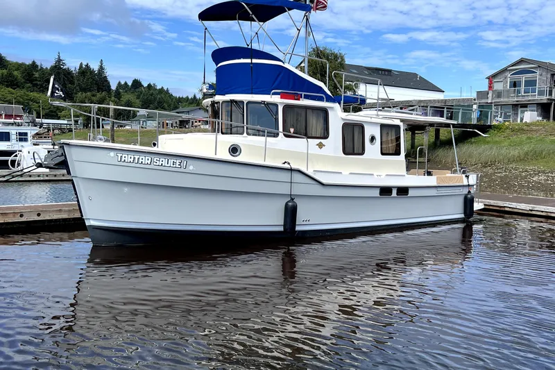  Yacht Photos Pics 2021 Ranger Tugs R-31 CB boat docked in a marina, featuring a blue canopy.