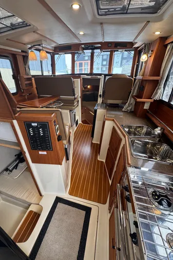 Yacht Photos Pics 2021 Ranger Tugs R-31 CB interior with wood finish, kitchen, and seating area.