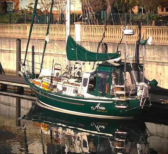Aria Yacht Photos Pics Pacific Seacraft 37 sailboat, 2000 model, docked with green sails and reflection in water.
