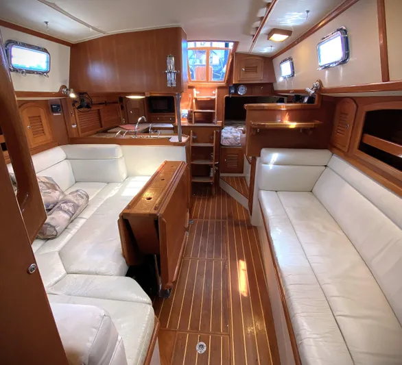 Aria Yacht Photos Pics Interior of 2000 Pacific Seacraft 37 yacht with wooden finish and white seating.