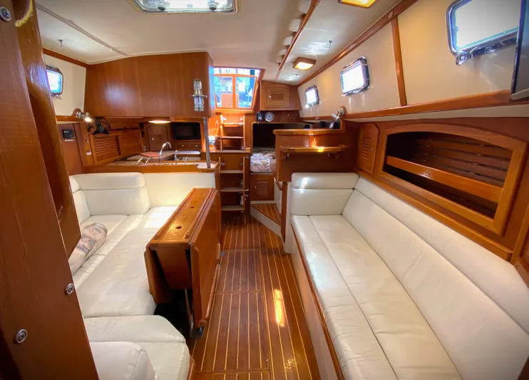 Aria Yacht Photos Pics Interior of 2000 Pacific Seacraft 37 yacht with wooden finish and white seating.