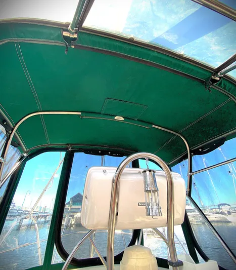 Aria Yacht Photos Pics Interior view of a 2000 Pacific Seacraft 37 sailboat cockpit with green canopy.